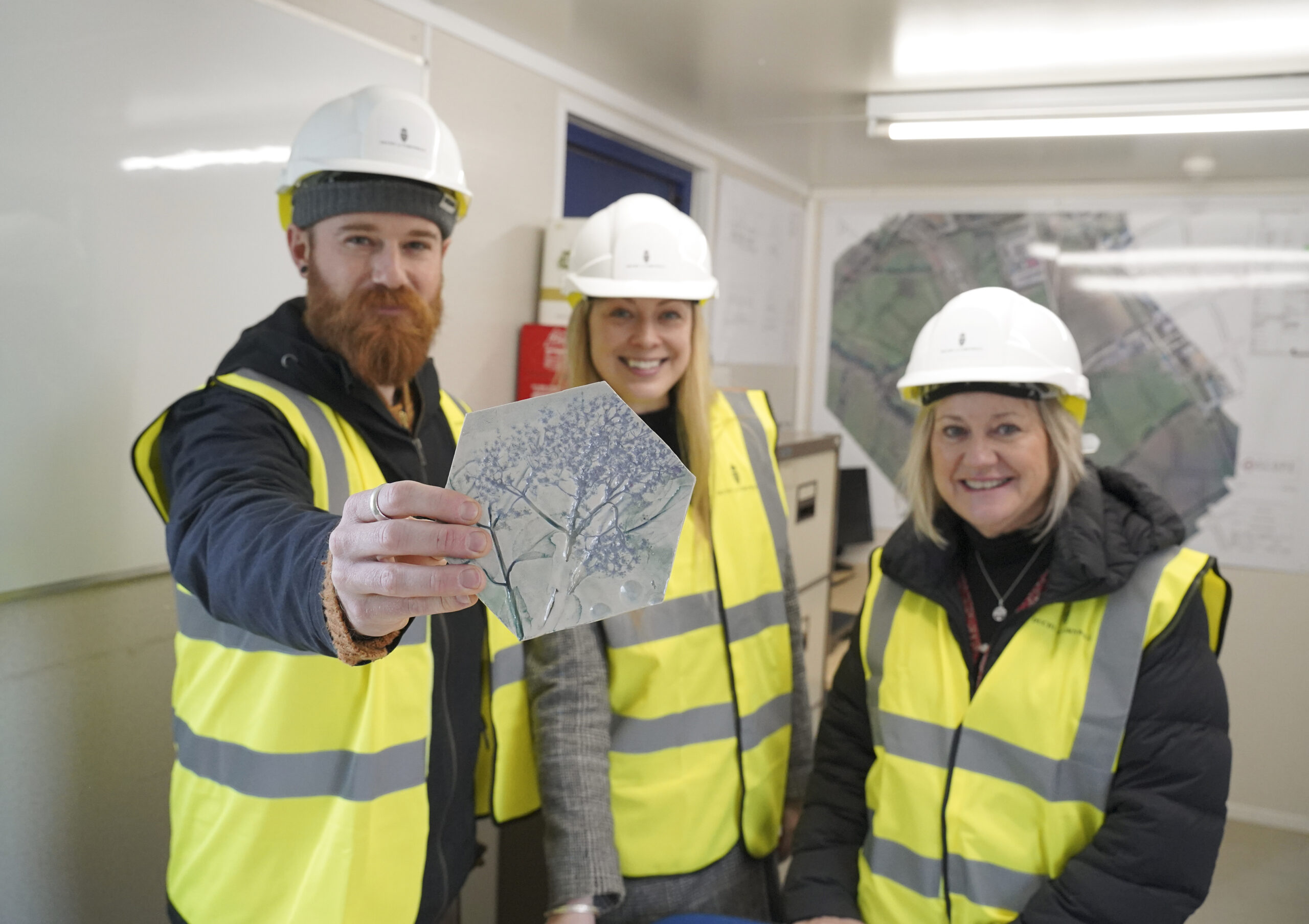 Tom Richardson, director; Sarah Hood, senior manager; Mandy Richardson, managing director of Naturally Learning with some of the tiles made by local families for Nansledan's new nursery.
