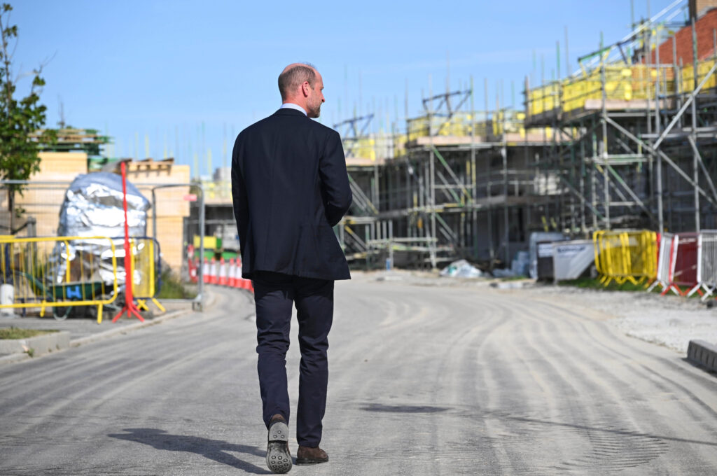 Duke Of Cornwall Man In A Suit Walking Down A Street With Scaffolding In The Background