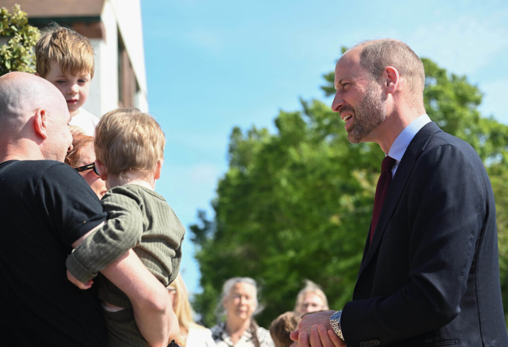 Duke Of Cornwall There Are Two Men Shaking Hands With A Child In A Crowd