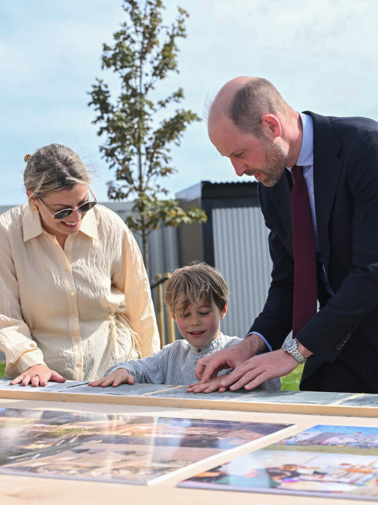 Duke Of Cornwall There Are Two People And A Child Looking At Pictures On A Table