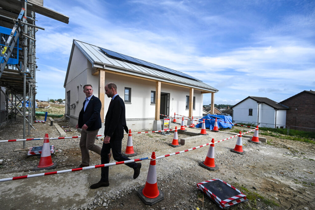 Duke Of Cornwall Two Men Walking In Front Of A House With Construction Cones